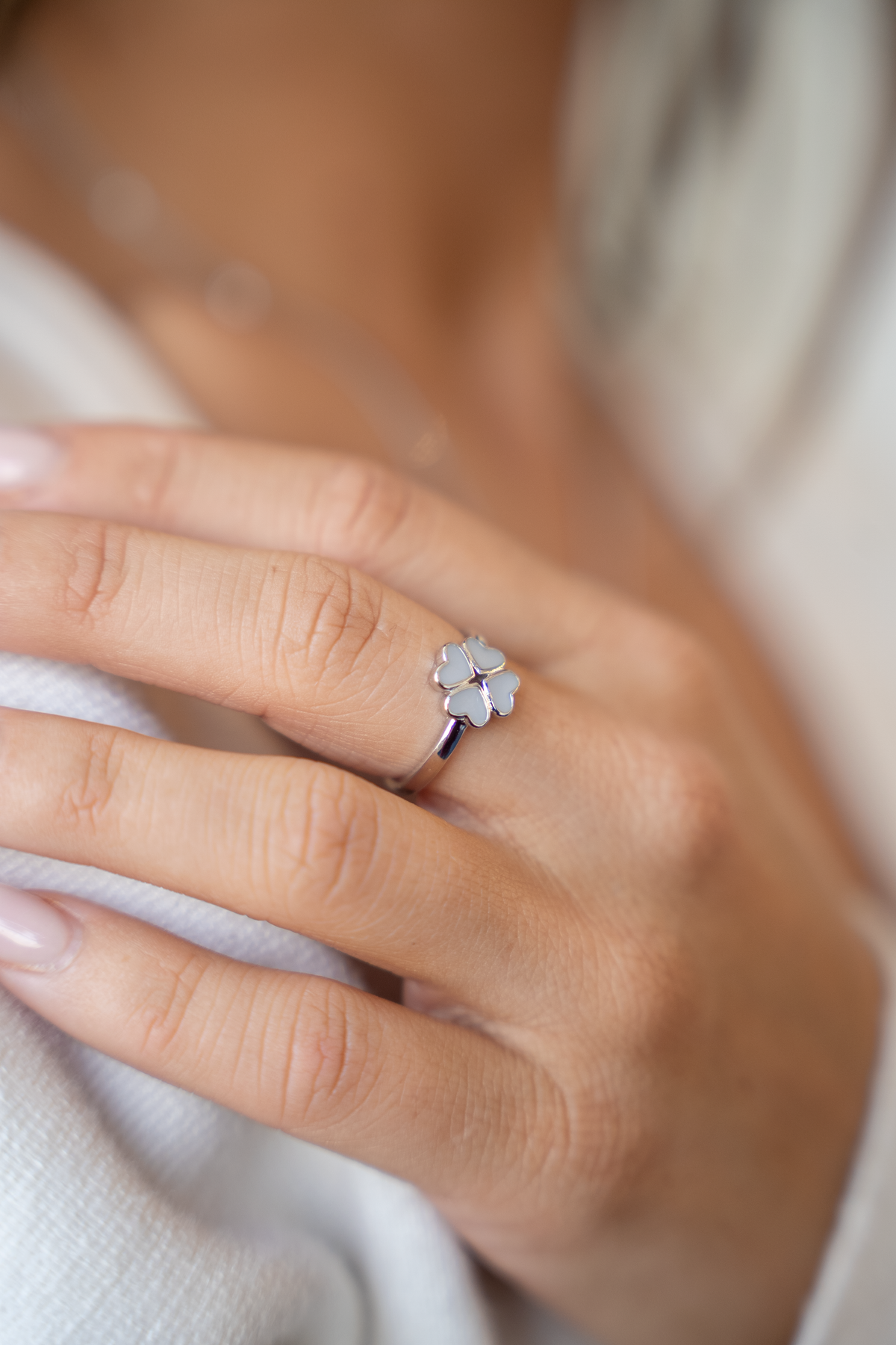 Lucy clover breast milk ring in white gold on the finger, close-up of the clover ring on a hand