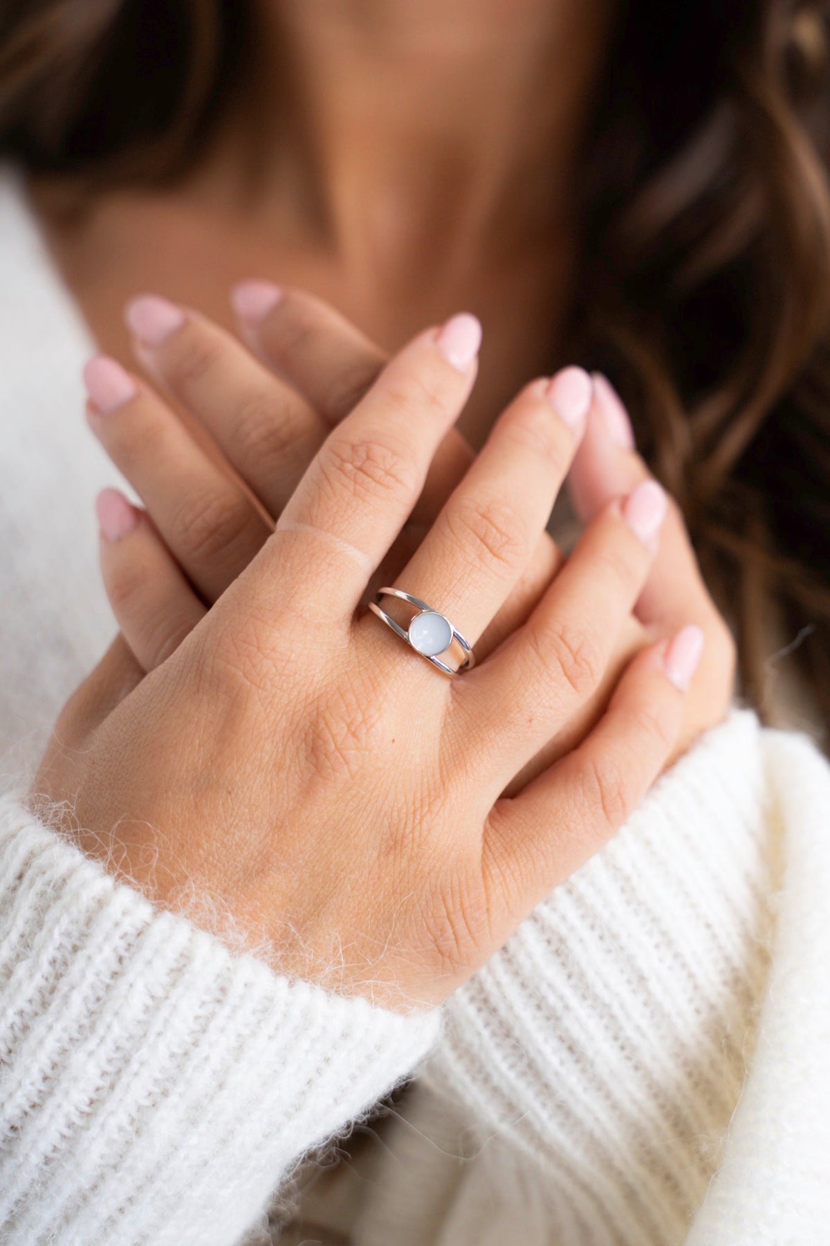 Hands crossed over the chest with the silver Bea breast milk ring on the ring finger.