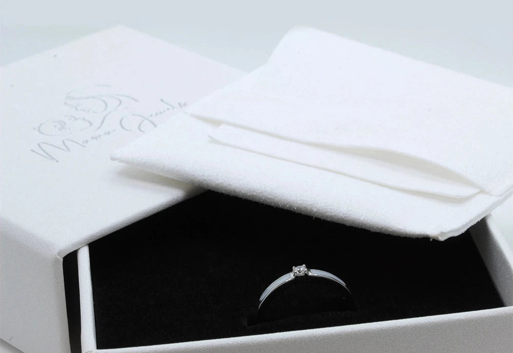 Silver Cinderella breast milk ring with a clear center stone in a white Mama Jewels gift box