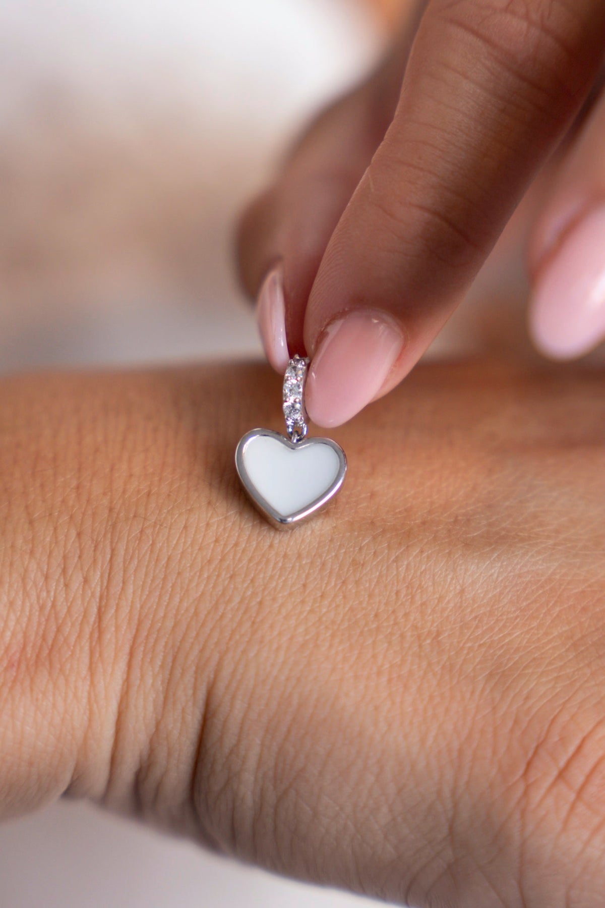 Close-up of the Indy heart charm in 925 sterling silver with white breast milk.