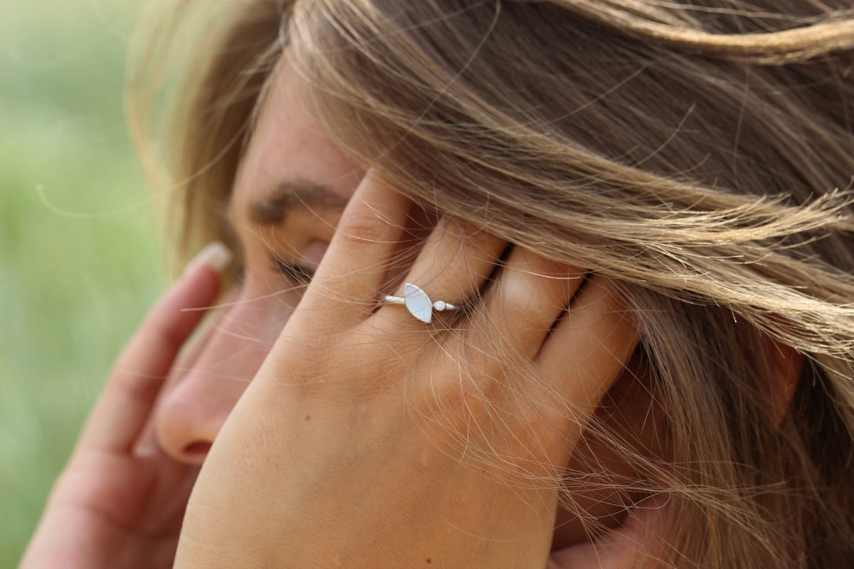 Lina ring in white gold on the finger, close-up of a hand held over the face