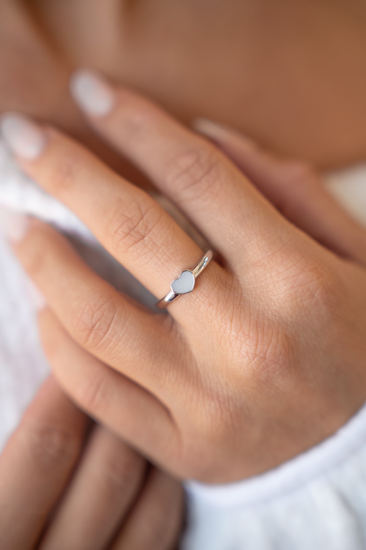 Lisa heart ring in white gold on the finger, close-up of the heart ring on a hand